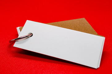 Close up of white banner shape notepad with customizable space for text on red cover background. Copy space concept.
