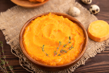 Sweet potato porridge in wooden bowl on wooden background. Diet, healthy eating. side view, selective focus