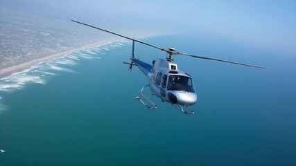 Helicopter soaring over coastline on a clear day with waves below