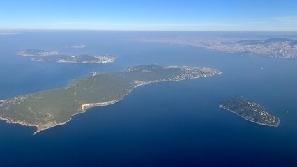 An aerial shot of the Prince's Islands with coastal Istanbul in the background on a sunny day