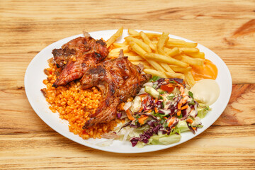 Assiette de côtelettes d’agneau servie avec blé, frites et salade – restauration rapide turque halal
