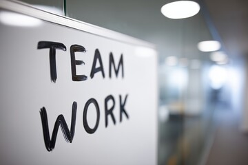 Close-up of whiteboard with handwritten TEAM WORK in modern office setting