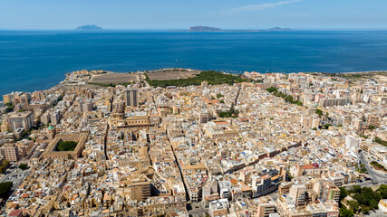 Aerial view of houses and buildings in the historic center of Marsala, in the province of Trapani, Sicily, Italy. In the background, on the horizon, are the Mediterranean Sea and the Aegadian Islands.