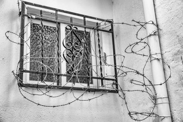 window with bars and barbed wire