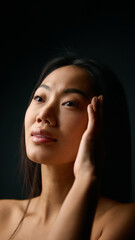 Fototapeta premium Woman touching temple with calm expression and balanced natural beauty. Concept of stress relief, mindfulness, skincare awareness, and emotional stability in personal wellness.