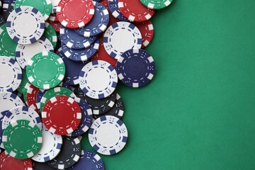 Casino gaming background with stacks of betting chips of different colors on green gaming mat