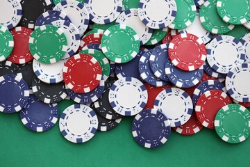 Casino gaming background with stacks of betting chips of different colors on green gaming mat
