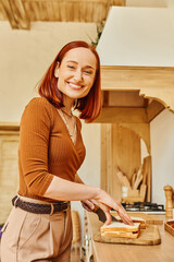 Happy redhead woman cooking in a cozy kitchen