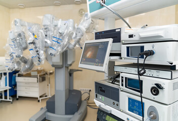 Advanced robotic surgery equipment in hospital room. Modern robotic surgical system with monitors and mechanical arms in sterile operating room