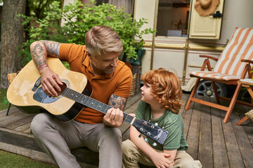 Connecting through music, a father and child share joyful moments outdoors