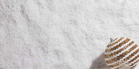 gold and white christmas ball on white snow background,christmas decoration on a snow background...