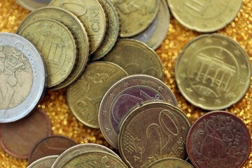 Big amount of euro coins on golden glitter background