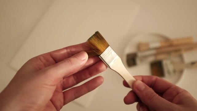 Closeup slow motion video of an abstract acrylic or oil painting in pastel pink and green colors. Creative process of an artist painting on canvas. State of flow and creativity.