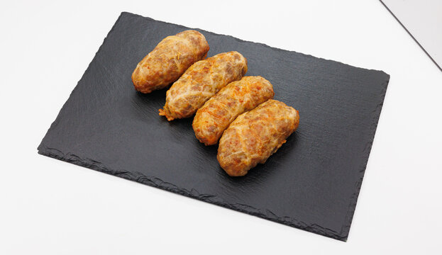 Four Grilled Abkhazura Sausages On Black Slate Platter Ready To Serve As Appetizers