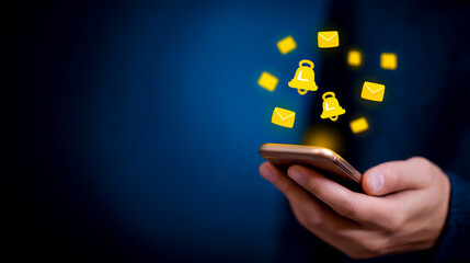 A person holding a smartphone with yellow bell and message icons floating above it