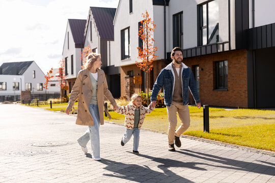 Family walking child in a suburban residential neighborhood