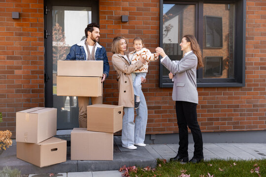 Real estate agent handing keys to a young happy family
