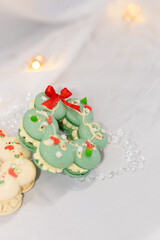 macaron dessert in shape of christmas wreath. homemade unique cookie. bow and sprinkles. white and green. isolated