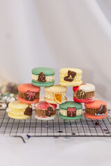 macaron dessert for christmas. homemade unique cookie. bow and sprinkles. various colors. present box. white