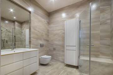 Modern bathroom with elegant fixtures and spacious design featuring glass shower and stylish storage solutions in a contemporary home