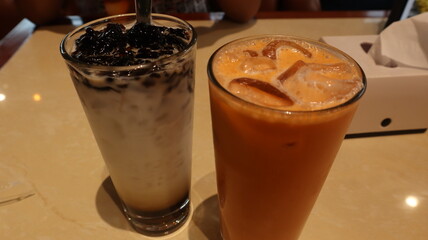 drinks on a table with a cafe in the background.