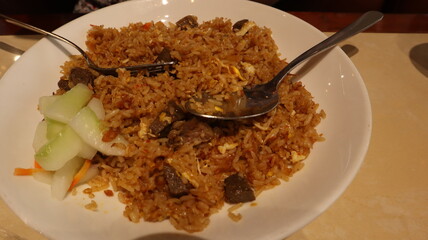 Enjoy fried rice with meat topping, a signature Indonesian food.