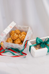 christmas sweet profiteroles. decorated in gift box. tasty dessert. white background