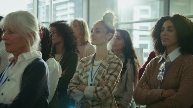 Professionals attend a corporate conference, listening attentively to a speaker. This group of businesspeople are focused and engaged, absorbing new information in a professional setting.