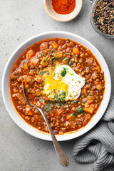 assiette de soupe de lentilles à la tomate, carottes et oeuf poché