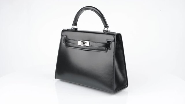 Seamless 4K 360&deg; rotation of a luxurious black leather handbag in classic Birkin style. Elegant gold hardware, smooth texture, and refined design for premium fashion and product showcase.