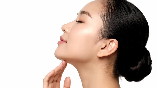 Closeup profile of a beautiful young asian woman with eyes closed, touching her chin