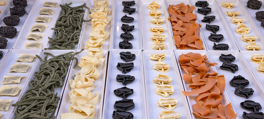 local Italian restaurant with elegant showcase of various homemade pasta. assortment of pasta in different shapes and colors. mediterranean culinary