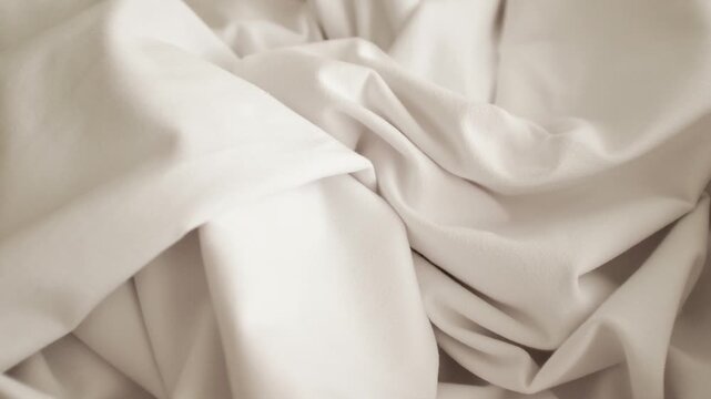 Closeup slow motion video of white knitwear stretching elastic fabric for t-shirts. Appreciating pleasant texture of high quality textile for clothes. Soft and cosy textile. Expensive fabric.