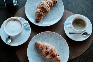 two croissants and two cups of coffee