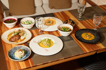 Enjoy a Gourmet Dining Event with a Variety of Delicious Dishes on a Beautiful Wooden Table