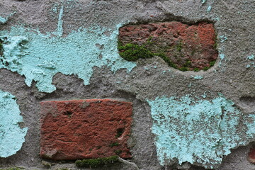 Background of a crumbling wall made of red clay brick and turquoise painted cement plaster