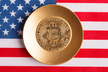 Bitcoin on a gold plate against the backdrop of the US flag