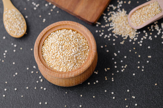 Quinoa seeds in multiple wooden bowls and spoons on dark background - Powered by Adobe