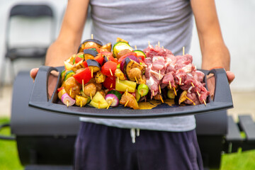 A man fries vegetables and meat on the grill. Selective focus.