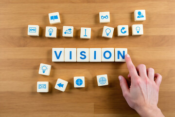 Vision Concept: Scrabble Tiles Spelling "Vision" with Hand Pointing, Surrounded by Idea & Strategy Icons on Wood Background, Flat Lay