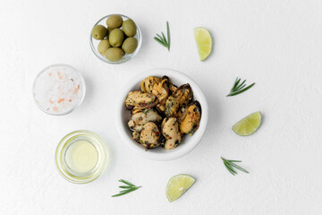 Single seafood bowl with lime and herbs on white table for minimalist gourmet or ingredient styling concept