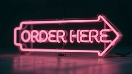 Bent neon "ORDER HERE" arrow sign illuminates dark surface against dark background, call-to-action banner