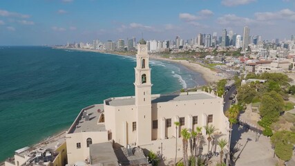 Aerial view of the cream-colored St. Peter Church with a bell tower, standing proudly against a backdrop of the city and the sea, Old Jaffa, Tel Aviv-Yafo, Israel.