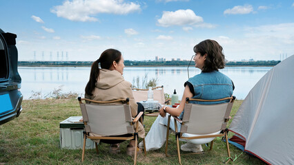 Two women enjoying a relaxing camping by the lake