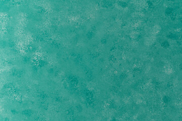 Mint green mottled plaster wall texture with subtle light effect