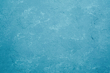 Blue wall with rough plaster texture and mottled grunge surface