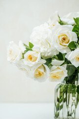 Closeup of white roses bouquet with green leaves in soft natural light