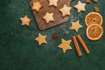 Christmas star cookie dough and oranges on green background for festive baking and seasonal concept