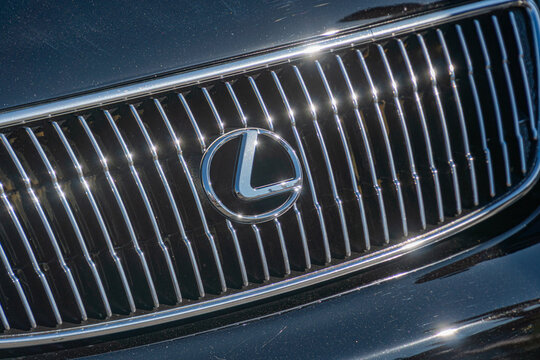 Close-up view of a Lexus car, angled from above, with a dark colored grille featuring a complex pattern and LED elements, prominently displaying the brand logo - Kyiv, Ukraine - September 21, 2025