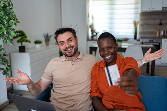 Couple enjoying a fun moment while using a laptop in a modern living room